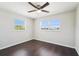 Bright bedroom features two windows, ceiling fan and rich dark wood-look flooring at 556 Lowell Nw Ave, Port Charlotte, FL 33952