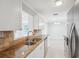 Bright kitchen featuring stone countertops, stainless steel appliances, and white cabinets at 556 Lowell Nw Ave, Port Charlotte, FL 33952