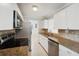 Modern kitchen with stainless steel appliances, granite countertops, and white cabinets at 556 Lowell Nw Ave, Port Charlotte, FL 33952