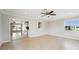 Open living room with tile flooring, neutral walls, ceiling fan and view to the kitchen at 556 Lowell Nw Ave, Port Charlotte, FL 33952