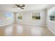 Bright living room with tile flooring, neutral walls, three large windows and a ceiling fan at 556 Lowell Nw Ave, Port Charlotte, FL 33952