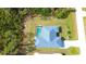 An aerial view of the back of the home showing the screened in pool and surrounding wooded area at 6170 David Blvd, Port Charlotte, FL 33981