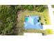 An aerial view of the back of the home showing the screened in pool and surrounding wooded area at 6170 David Blvd, Port Charlotte, FL 33981