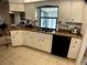 Bright kitchen features a stainless steel sink, granite countertops, and white cabinetry at 6170 David Blvd, Port Charlotte, FL 33981