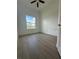 Well-lit bedroom with wood-look flooring, a modern ceiling fan, and white walls at 6372 Grove Blvd, Punta Gorda, FL 33982