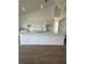 Close-up of a modern kitchen island, and white cabinets with contrasting dark hardware, and stainless steel appliances at 6372 Grove Blvd, Punta Gorda, FL 33982