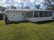 Back view of the house featuring a screened in porch and back yard at 710 Aqui Esta Dr, Punta Gorda, FL 33950