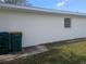 Back view of the house featuring trashcans and a small window at 710 Aqui Esta Dr, Punta Gorda, FL 33950