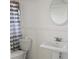 A clean bathroom features a white sink and toilet, complemented by a striped shower curtain at 710 Aqui Esta Dr, Punta Gorda, FL 33950