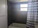 Modern bathroom showcasing dark tile walls, shower-tub, and stylish curtain at 710 Aqui Esta Dr, Punta Gorda, FL 33950