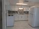 Well-lit kitchen with updated appliances, bright white cabinets, and elegant backsplash at 710 Aqui Esta Dr, Punta Gorda, FL 33950
