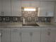 Kitchen with tile backsplash, updated white cabinetry and counter tops at 710 Aqui Esta Dr, Punta Gorda, FL 33950