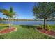 Scenic lake view in a well-maintained backyard with lush green grass and mature trees at 7346 Talon Bay Dr, North Port, FL 34287