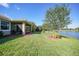 Lush green backyard with mature trees and a serene view of the lake at 7346 Talon Bay Dr, North Port, FL 34287