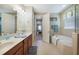 Bright bathroom with double vanity, soaking tub, and access to the bedroom at 7346 Talon Bay Dr, North Port, FL 34287