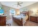 Comfortable bedroom featuring wood furniture, ceiling fan, and coastal-themed decorations at 7346 Talon Bay Dr, North Port, FL 34287