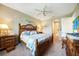 This bedroom offers a wood bed frame, ceiling fan and a view into the en-suite bathroom at 7346 Talon Bay Dr, North Port, FL 34287