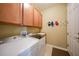 Functional laundry room featuring front load washer/dryer, sink, counter, and storage cabinets at 7346 Talon Bay Dr, North Port, FL 34287