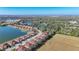 Aerial view of a neighborhood with lush greenery, lakes, and a clear blue sky at 8858 Tuscany Isles Dr, Punta Gorda, FL 33950