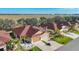 Aerial view of beige homes with red roofs, green lawns, and palm trees in a planned community at 8858 Tuscany Isles Dr, Punta Gorda, FL 33950