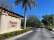 Community entrance sign for Tuscany Isles is surrounded by greenery with a blue sky at 8858 Tuscany Isles Dr, Punta Gorda, FL 33950