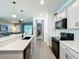 Kitchen with gray cabinets, island with seating, and stainless steel appliances at 8858 Tuscany Isles Dr, Punta Gorda, FL 33950