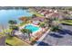 Community pool area with lounge chairs, palm trees, and a lake view at 8858 Tuscany Isles Dr, Punta Gorda, FL 33950