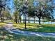 Scenic view of the walking path with mature trees and lake view at 8858 Tuscany Isles Dr, Punta Gorda, FL 33950