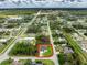 Wide aerial shot capturing a residential area featuring a home on a corner lot surrounded by trees and landscaping at 1022 S Lavina St, North Port, FL 34286