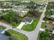 An aerial view of a single-story home featuring a white exterior, surrounded by lush greenery and a well-kept lawn at 1022 S Lavina St, North Port, FL 34286