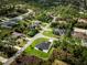 Expansive aerial view of a modern home with lush green lawn and mature trees in a peaceful neighborhood setting at 1022 S Lavina St, North Port, FL 34286