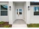 Welcoming front entrance featuring double doors, black sconces and clean landscaping at 1022 S Lavina St, North Port, FL 34286