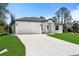 A well-maintained, single-story home boasts a white exterior, two-car garage, and a spacious concrete driveway at 1022 S Lavina St, North Port, FL 34286