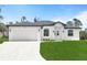 A charming single-story home featuring a white exterior, attached two-car garage, and a well-manicured lawn at 1022 S Lavina St, North Port, FL 34286