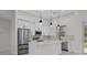 Bright kitchen features white cabinets, stainless steel appliances, and an island with a white countertop at 1022 S Lavina St, North Port, FL 34286