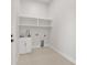 Bright laundry room features white cabinetry, shelving, stainless steel sink and neutral flooring at 1022 S Lavina St, North Port, FL 34286