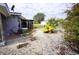 Backyard featuring a stone area with a garden, tropical plants, and a screened-in porch at 21422 Mallory Ave, Port Charlotte, FL 33952