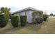 Exterior view of the home with manicured bushes and lawn on a sunny day at 21422 Mallory Ave, Port Charlotte, FL 33952