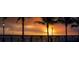 A peaceful waterfront view with palm trees and a bridge during sunset at 21422 Mallory Ave, Port Charlotte, FL 33952