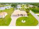 Aerial view of a pink house with a circular driveway near a lake at 256 Coblentz St, Port Charlotte, FL 33954