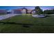 Pink house with landscaped yard, driveway, and stone accents at dusk at 256 Coblentz St, Port Charlotte, FL 33954