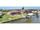 Aerial view showcasing home, pool, canal, boat lift, and lush landscaping at 15706 Viscount Cir, Port Charlotte, FL 33981