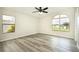 Bright bedroom with wood-look floors, large windows, and ceiling fan at 6287 Oriole Blvd, Englewood, FL 34224