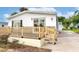 Single-wide home with gray and white exterior, wooden deck, and stone patio at 6287 Oriole Blvd, Englewood, FL 34224