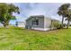 Mobile home side yard with green grass and landscaping at 6287 Oriole Blvd, Englewood, FL 34224