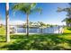 Tranquil waterfront view, lush green lawn, and palm trees at 1080 Bal Harbor Blvd # 1C, Punta Gorda, FL 33950