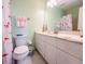 Clean bathroom featuring a toilet, vanity with flamingo-themed decor, and shower with a fun curtain at 13468 Romford Ave, Port Charlotte, FL 33981