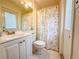 Bright bathroom features a vanity with gold fixtures and a shower with colorful fish curtain at 13468 Romford Ave, Port Charlotte, FL 33981