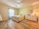 Cozy bedroom featuring wood-look flooring, a ceiling fan, and a window with natural light at 13468 Romford Ave, Port Charlotte, FL 33981