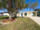 Charming home featuring white exterior with colorful blue door and yellow trim details at 13468 Romford Ave, Port Charlotte, FL 33981